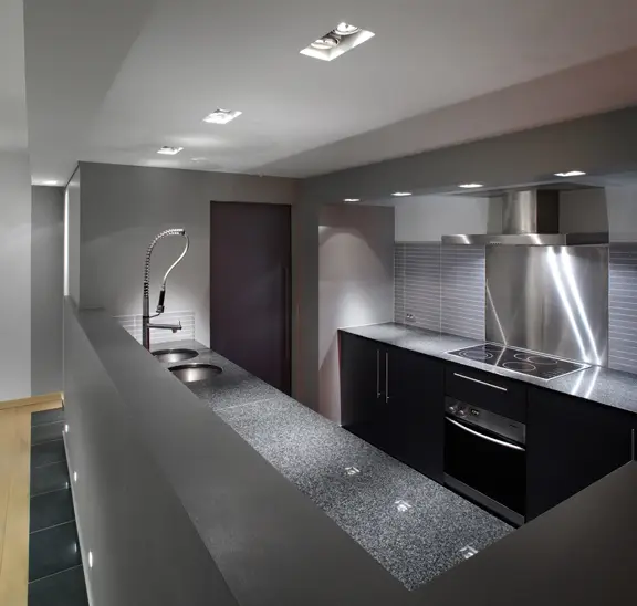 Strakke en moderne keuken met ingebouwde verlichting en zwart-witte accenten.